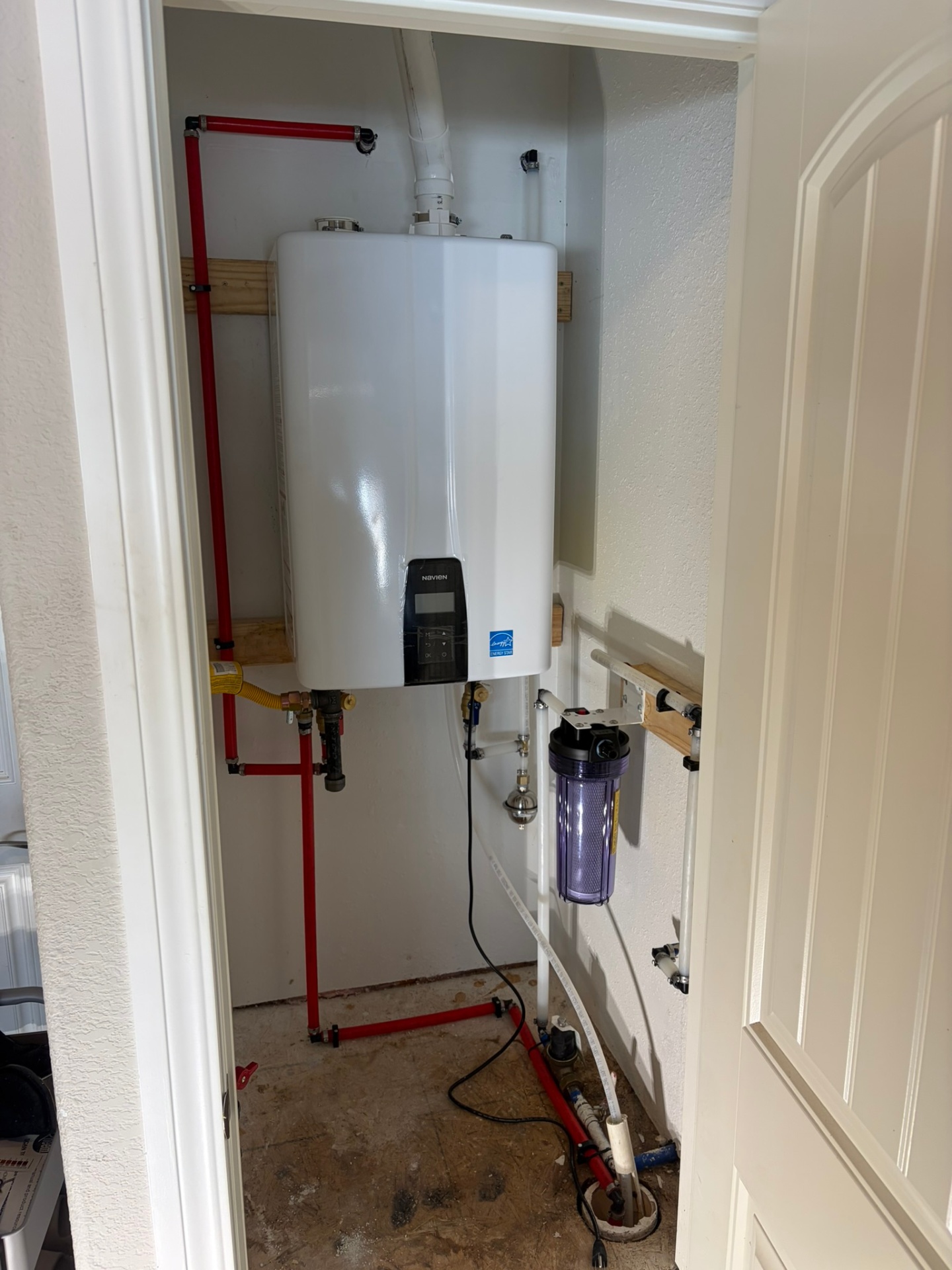 Completed tankless water heater installation by United Plumbing in Rogers, Arkansas.