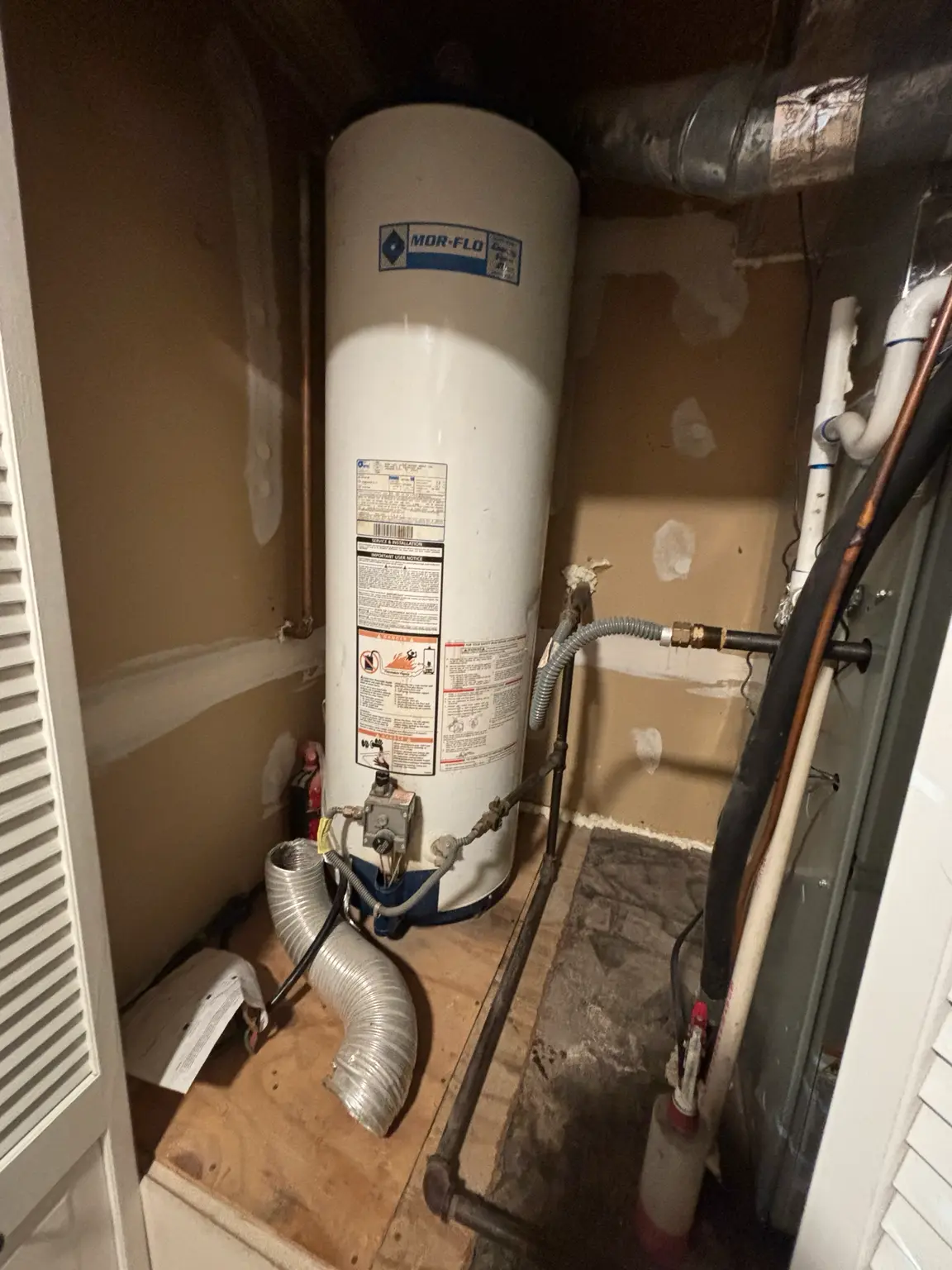 Aging natural gas water heater before replacement in Fayetteville, Arkansas.