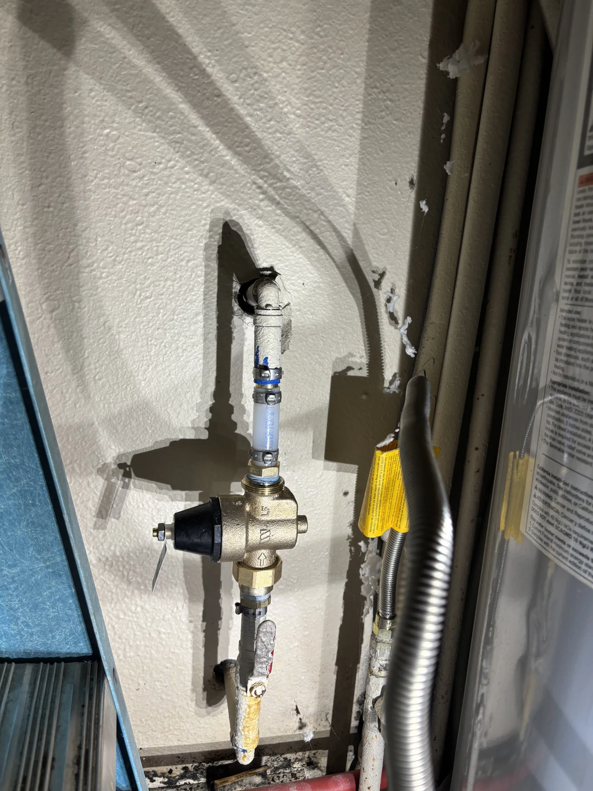 New water pressure regulator installed by United Plumbing in a water-heater closet in Fayetteville, Arkansas.